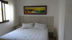 1 cama en un dormitorio con una foto en la pared en Apartamento Residencial Mediterrâneo Iberostate Praia do Forte, en Mata de Sao Joao