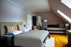 - une chambre avec un lit et un canapé dans l'établissement Acedo Land- und Sporthotel Levenhagen Greifswald, à Levenhagen