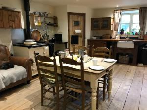 a kitchen and living room with a table and chairs at Pleck Barn B&B in Ansty