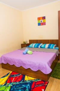 オムスクにあるRENT-сервис Апартаменты на Иртышской набережной 28のベッドルーム(紫の毛布を使用した大型ベッド1台付)