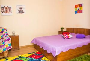 オムスクにあるRENT-сервис Апартаменты на Иртышской набережной 28のベッドルーム1室(紫のシーツと枕が備わるベッド1台付)