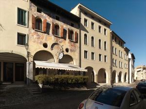 un bâtiment avec une voiture garée devant lui dans l'établissement Hotel Canon d'Oro, à Conegliano