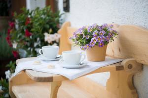 een tafel met twee koffiekopjes en bloemen erop bij Ferienwohnung "Zum Leitnerbachl" in Schliersee