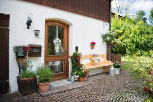 een huis met een wastafel en planten ervoor bij Ferienwohnung "Zum Leitnerbachl" in Schliersee