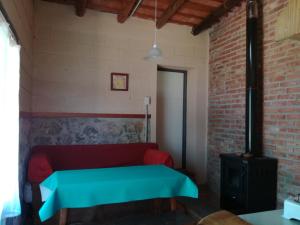 a room with a red couch and a brick wall at Espejo Escondido in Tanti