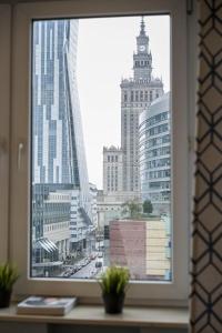 ein Fenster mit Blick auf eine Stadt mit hohen Gebäuden in der Unterkunft Gold Apartment Złota - Palace of Culture View- NETFLIX-Free Parking 500 meters from the apartment in Warschau