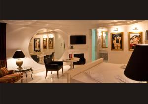een woonkamer met een bank, een tafel en een spiegel bij Miami Motel ( ADULT ONLY ) in Pindamonhangaba