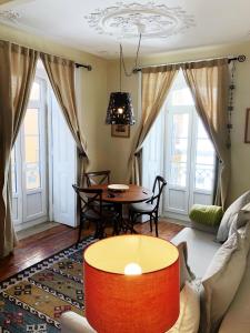 リスボンにあるRemodeled Historic Apartment in Bairro Altoのリビングルーム(テーブル、ソファ付)