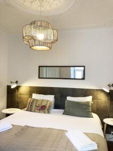 a bedroom with a large bed and a chandelier at Remodeled Historic Apartment in Bairro Alto in Lisbon