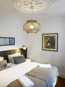 a bedroom with a large bed and a chandelier at Remodeled Historic Apartment in Bairro Alto in Lisbon