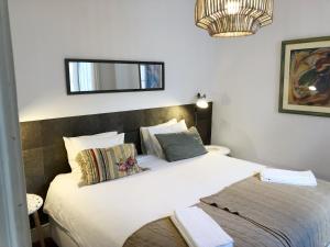 a bedroom with a large white bed with pillows at Remodeled Historic Apartment in Bairro Alto in Lisbon