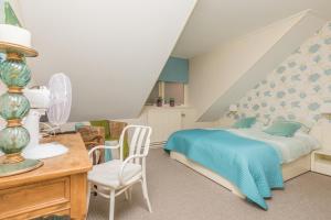 a bedroom with a bed and a desk and a chair at Hotel-Restaurant van der Weijde in Noordgouwe