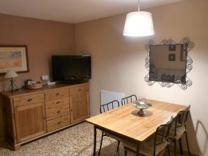 a dining room with a wooden table and a television at Apartamento Centrico CasaLos Olmos in Mora de Rubielos