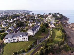 an aerial view of a house on a hill next to the ocean at Les Terrasses De La Comtesse in Saint-Quay-Portrieux