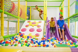 three children playing in a playground with balls at Holiday Park & Resort Niechorze Rewal in Niechorze