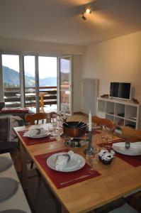 a dining room table with plates and wine glasses at Apartment Leysin - Swiss Alps - Fully Renovated ! in Leysin