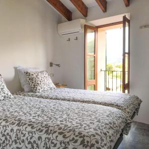 a bedroom with a bed with a black and white comforter at La Luna in Sóller