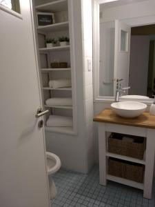 a bathroom with a sink and a toilet and a mirror at Habitania Bahia - Cochera opcional in Bahía Blanca