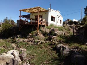 una casa al lado de una colina con rocas en Cabañas Wasi Mayu en Tafí del Valle