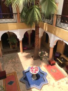 a room with a table and a palm tree at Riad Fatinat Marrakech in Marrakesh