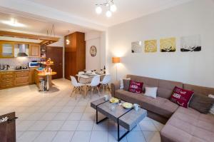 a living room and kitchen with a couch and a table at Pisces - City Center Apartment in Athens