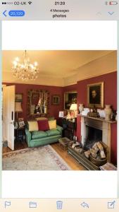 sala de estar con sofá verde y chimenea en 10 st james villas, en Winchester