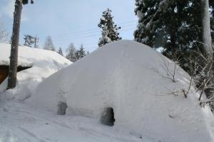 un iglú cubierto de nieve en un patio en B&B Santana Hakuba, en Hakuba