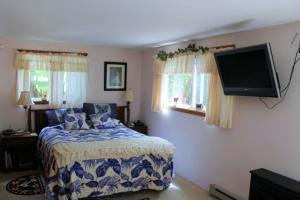 a bedroom with a bed and a flat screen tv at Country Goose in Volcano