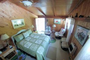 a bedroom with a bed and chairs in a room at Country Goose in Volcano