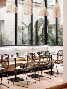 a dining room with a table and chairs and windows at Doisy Etoile in Paris