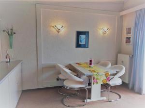 comedor con mesa y sillas blancas en Appartementhaus Himmelreich, en Lam