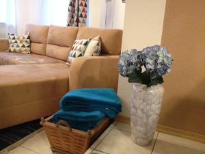 - un salon avec un canapé et un vase fleuri dans l'établissement FeWo Familie Walther, à Markdorf