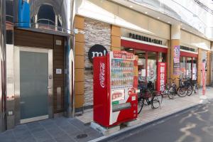 a cocacola machine on the side of a street at Rota Hostel in Osaka