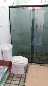 a bathroom with a toilet and a glass shower at Pousada dos Corações in Salvaterra