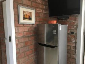 a brick wall with a television and a refrigerator at Bungalows Cerro Azul in Cerro Azul