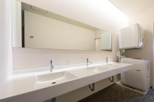 La salle de bains est pourvue de 2 lavabos et d'un grand miroir. dans l'établissement Rota Hostel, à Osaka