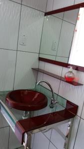 a bathroom with a red sink and a mirror at Pousada dos Corações in Salvaterra