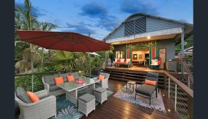 a house with a deck with a table and an umbrella at Jetavana in Eudlo