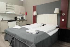 a bedroom with a large bed with towels on it at Oppdal Gjestetun Hotell in Oppdal