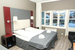 una habitación de hotel con una cama y una silla en Oppdal Gjestetun Hotell, en Oppdal