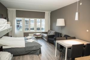 a hotel room with a bed and a living room at Oppdal Gjestetun Hotell in Oppdal