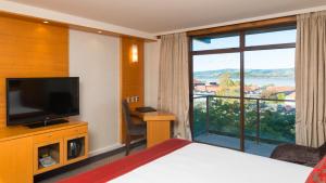 a hotel room with a bed and a large window at Millennium Hotel Rotorua in Rotorua