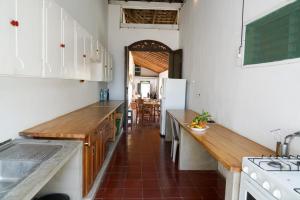 una cocina con armarios blancos y encimeras de madera en El Arca de Noe, en Granada