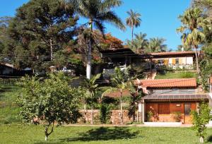 a house on a hill with palm trees at Chalé do Lago in Araxá