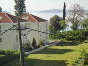 a house on a hill with a green yard at Apartments Roko in Kaštela