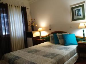 a bedroom with a bed and two lamps and a window at A Ponte - Saldanha in Lisbon