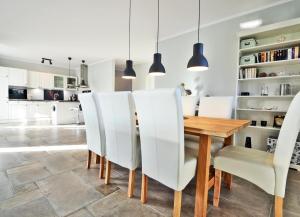 cocina y comedor con mesa de madera y sillas blancas en Ferienhaus Zirchow 3, en Zirchow