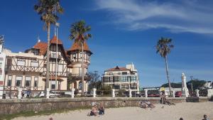 un edificio sulla spiaggia con palme e persone sulla sabbia di Lindas Vistas Apartment a Piriápolis