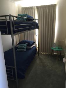a bedroom with two bunk beds and a table at Salt Air on Lochard Place in Warrnambool