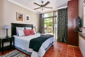 a bedroom with a bed with a fan and a window at 1202 on Cowgill in Pretoria